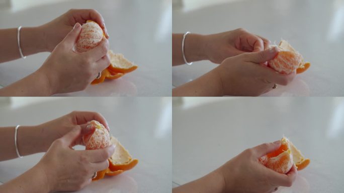 女性的手在餐桌上剥橘子