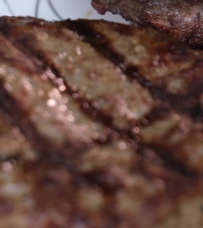 汉堡在燃烧的烤架上冷却，慢镜头。使用Phantom Flex 4K相机拍摄。