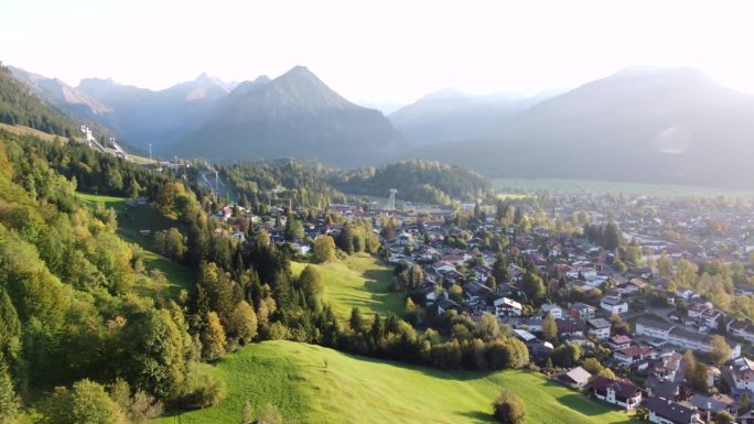 奥伯斯多夫度假村与山草甸和Allgäu阿尔卑斯山在傍晚的光，鸟瞰图