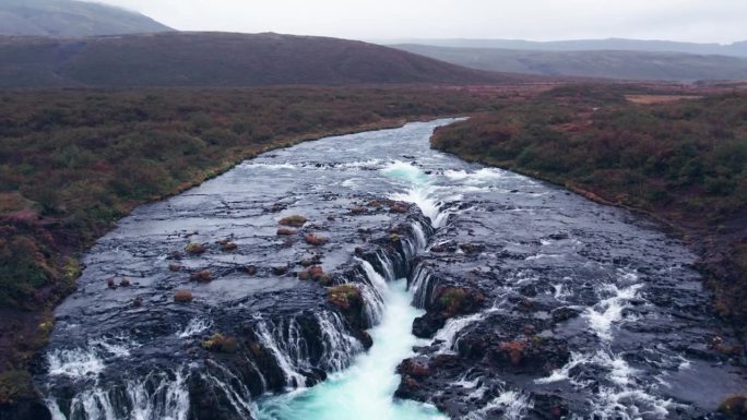 航拍:飞越布鲁尔福斯(Brúarfoss)从冰岛南部的黄金圈上落下的瀑布，非常风景如画，美丽的蓝色瀑