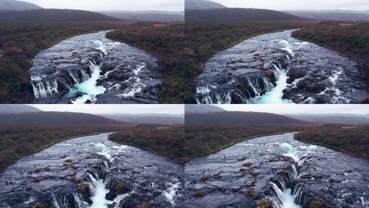 航拍:飞越布鲁尔福斯(Brúarfoss)从冰岛南部的黄金圈上落下的瀑布，非常风景如画，美丽的蓝色瀑