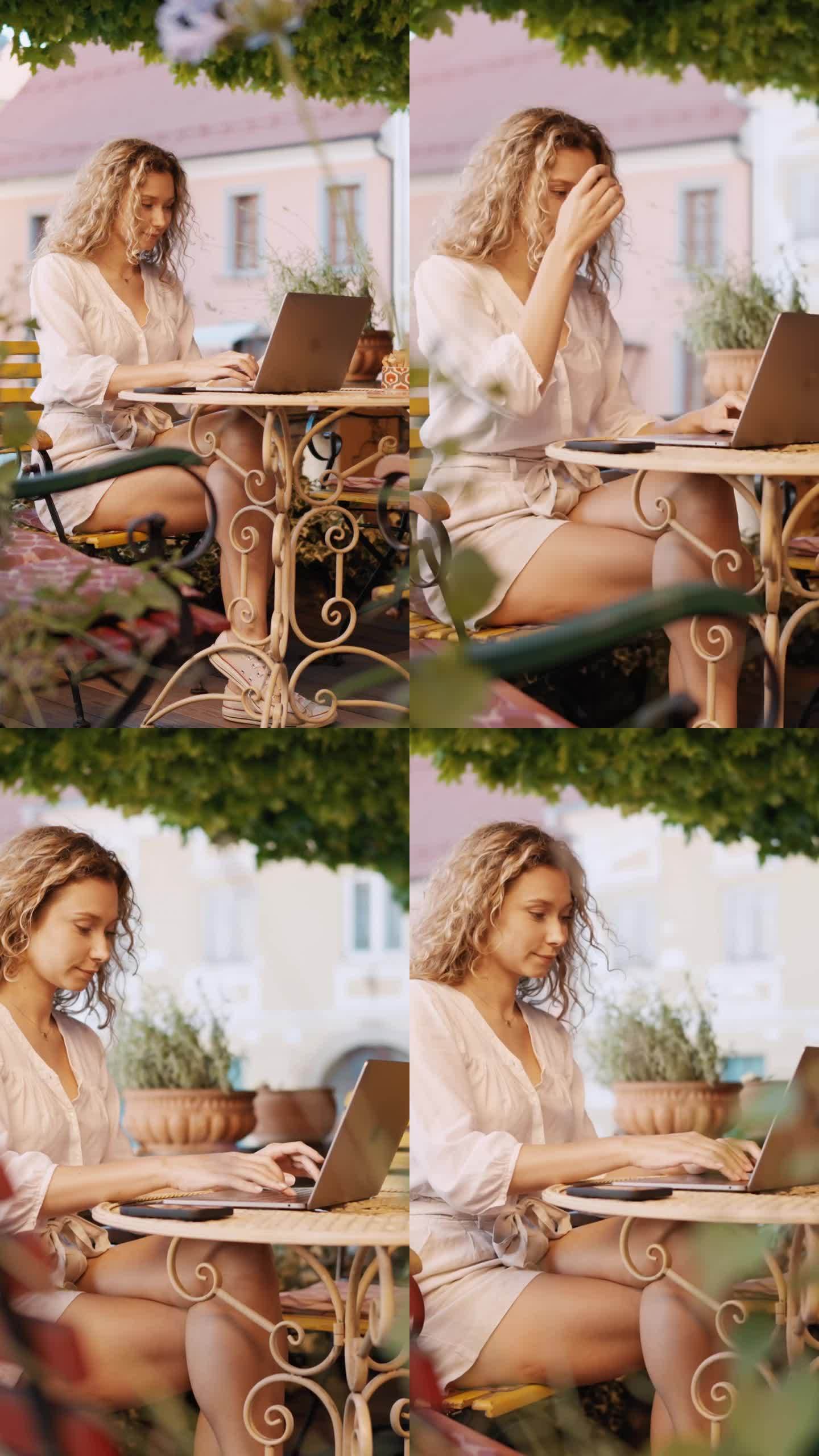 在Ptuj - VERTICAL老城的户外咖啡馆里，金发卷发的女人正在用笔记本电脑工作