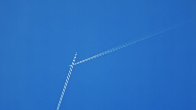 正下方的飞机相互交叉，在蓝色的天空中留下蒸汽痕迹