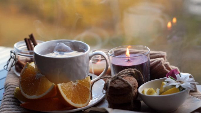 热水倒入茶包的杯子，温馨的家秋天的背景。在窗边喝茶