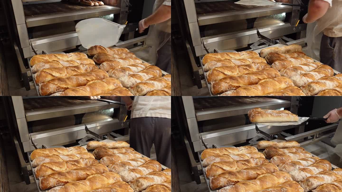 手工制作法式糕点的迷你面包店。面包师把刚烤好的热面包从烤箱里拿出来。烘焙产品的生产。传统的法国法棍面