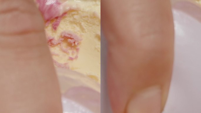 垂直视频。微距特写，用特制的冰淇淋勺从容器中舀出五彩缤纷的粉色冰淇淋。