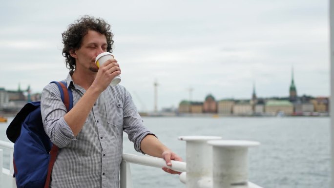 游客在斯德哥尔摩的一艘游船上一边喝咖啡一边欣赏风景