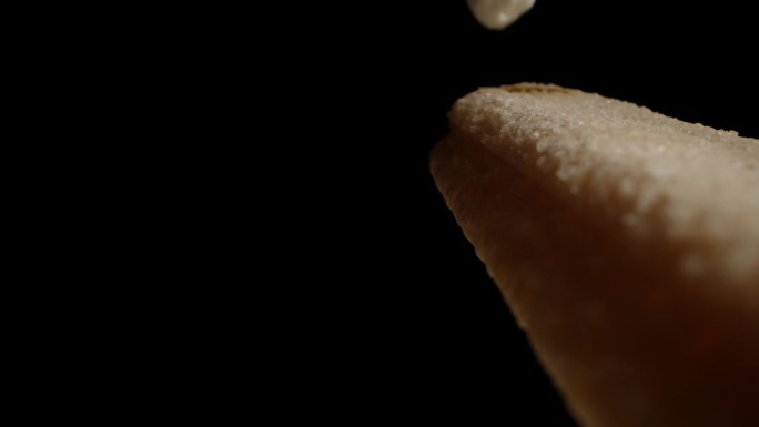 我把白奶油挤在黑色背景的Savoiardi饼干上。多莉滑块极端特写。