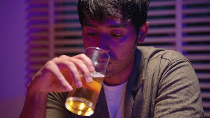一个年轻人坐在咖啡馆里喝啤酒，直到喝得酩酊大醉。