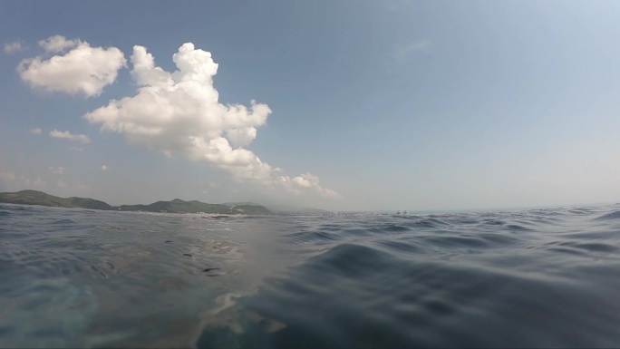 夏季室外游泳池的水波面，天空中有云的运动场景