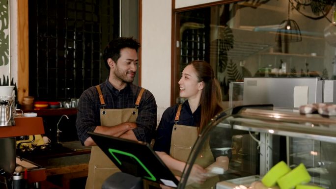 西班牙裔男子和咖啡店老板的妻子站在一起合影，宣传咖啡店。一个小的家庭企业，为社会上的人们互相了解关怀