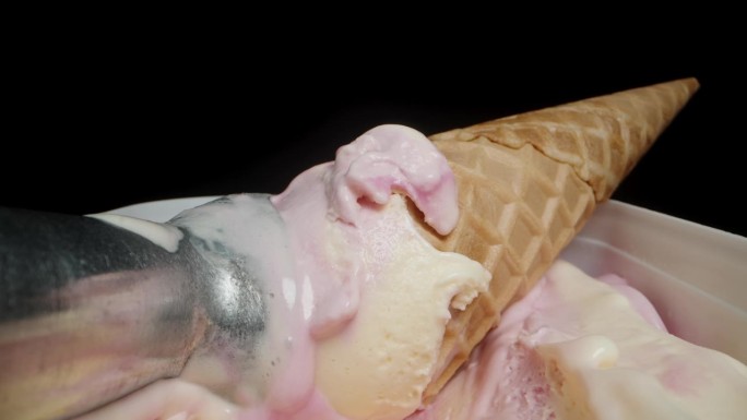 用来舀冰淇淋球的金属冰淇淋勺和华夫蛋筒一起放在容器里。当摄像机靠近时，我拿起了华夫蛋筒。