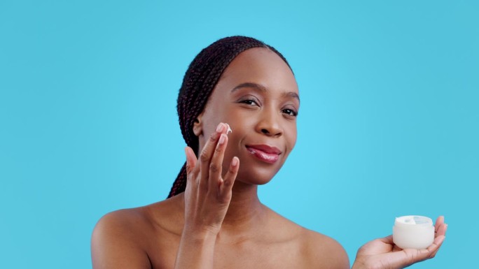 非洲女性，护肤霜和工作室，美容或皮肤科产品的健康蓝色背景。女孩，模特或微笑与转化，发光或美容变化与自