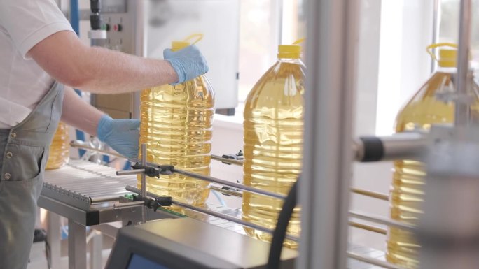 葵花籽油在生产线上的瓶身移动。葵花籽油装瓶生产线。植物油生产厂。高技术。工业背景