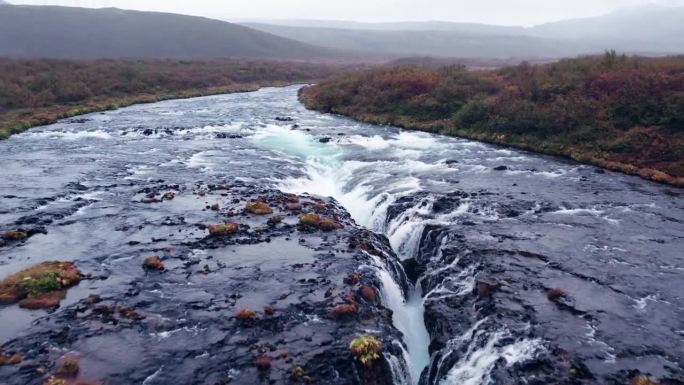 航拍:冰岛南部的布拉福斯瀑布(Brúarfoss)从黄金圈倾泻而下。它的风景如画，美丽的蓝色瀑布落入