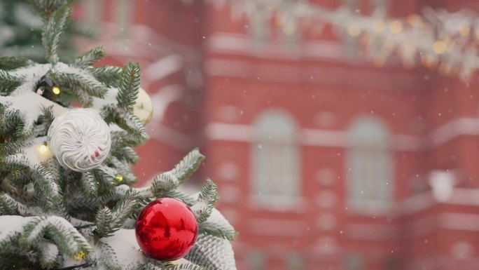 冬天外面的圣诞树。莫斯科红场背景上的圣诞树。圣诞节和新年的概念。冷杉树枝上的红色球，冬天的雪背景。喜