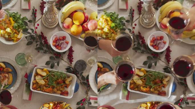 垂直屏幕:父母和客人在一个舒适的家里一起享受圣诞晚餐。亲戚们一起吃饭，举杯喝红酒，举杯祝酒，庆祝节日