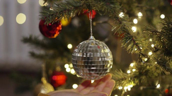 沉重的镜子球在人造圣诞树的树枝上旋转。
