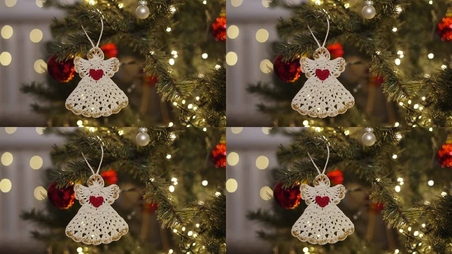 生态编织装饰形式的白色天使抱在圣诞树上。