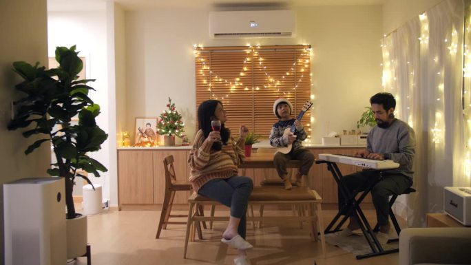 一个亚洲家庭在装饰精美的圣诞主题客厅里。