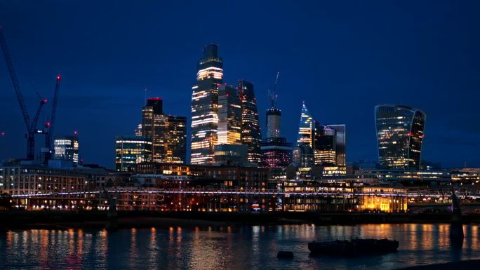 伦敦市中心的夜景，英国。市区的摩天大楼，泰晤士河上的千年桥，灯光明亮