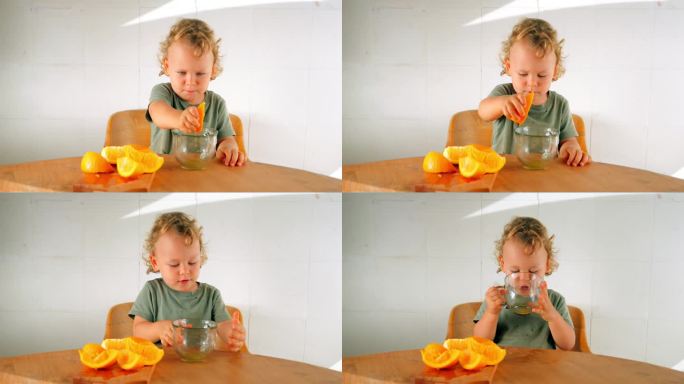 一个蹒跚学步的孩子榨了一片橘子汁，用他的小拳头捏了一下，然后喝了下去