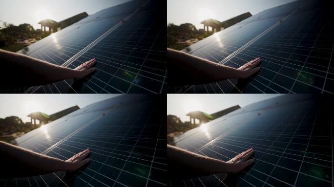日出时，手触摸并移动太阳能电池板