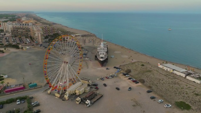 夏季Les Barcares海滩鸟瞰图。旅游旺季，海滩上有一座摩天轮和一艘巨轮作为吸引游客的景点