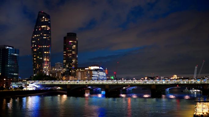 伦敦市中心的夜景，英国。摩天大楼和其他建筑，塔姆斯河上有桥梁，灯光很亮