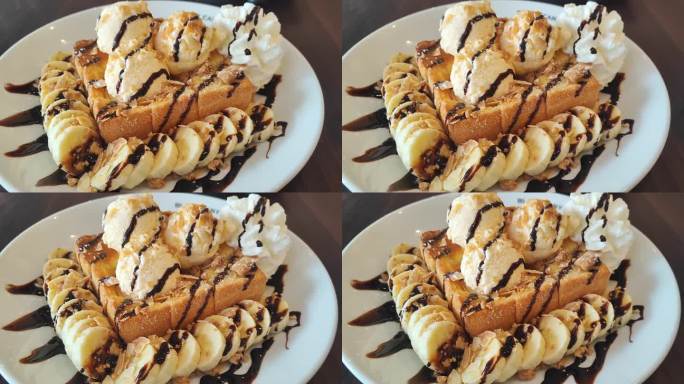 白色大理石餐桌上，蜂蜜吐司淋上香草冰淇淋和巧克力酱，配上香蕉片和鲜奶油。