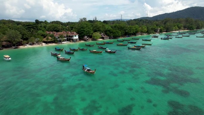 泰国利比岛，长尾船停泊在热带蓝色海水的海岸-空中旋转左