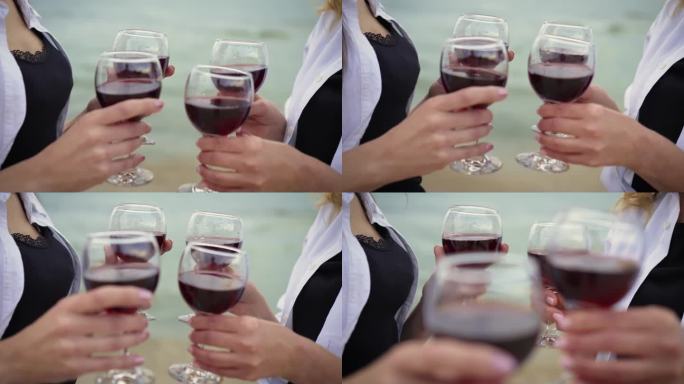 在特写镜头中，两个兴高采烈的女人向画面外的人递着几杯红酒