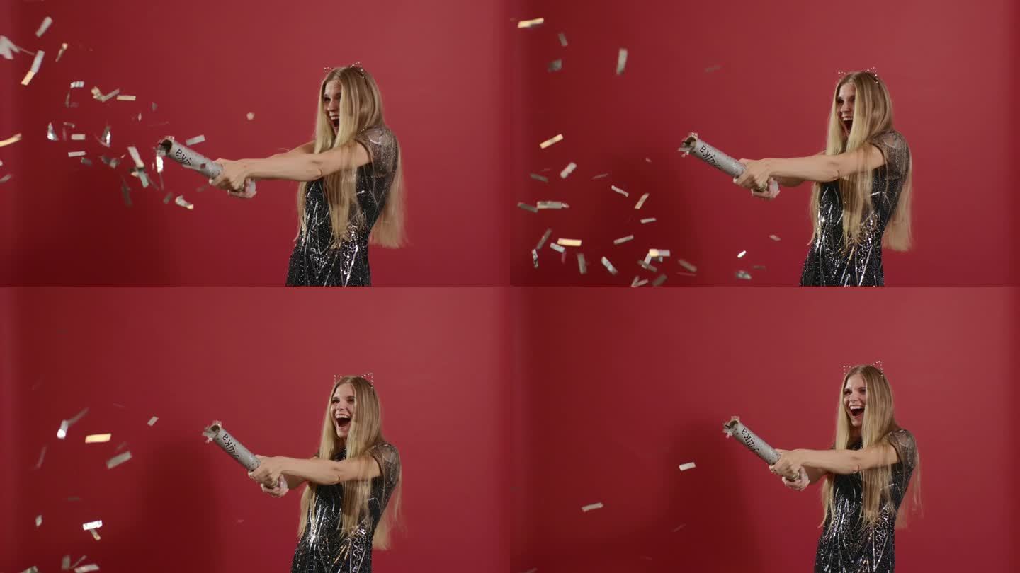 新年快乐!金发女孩在喜庆的红色背景上射击五彩纸屑。