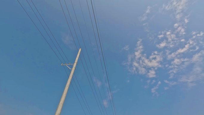 蓝天白云下的电线杆