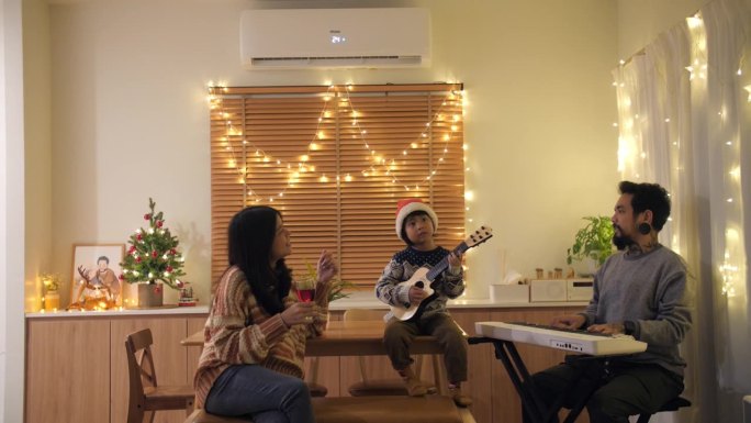 圣诞节，一家人和小儿子坐在客厅里欣赏音乐，一起在家里进行室内生活活动。