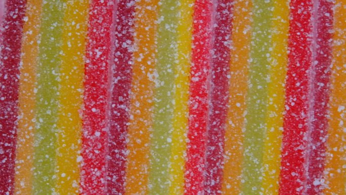 五彩缤纷的果冻糖果条在糖屑上