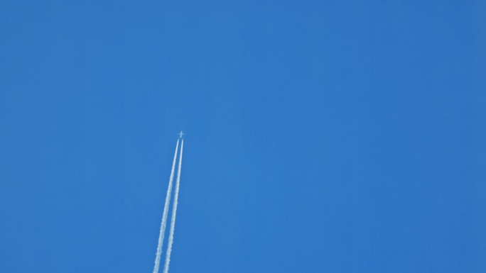 正下方的飞机在清澈的蓝天中直行时留下了水汽的痕迹