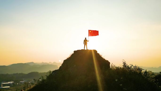 山顶举起红旗青年站在山顶举起五星红旗爱国