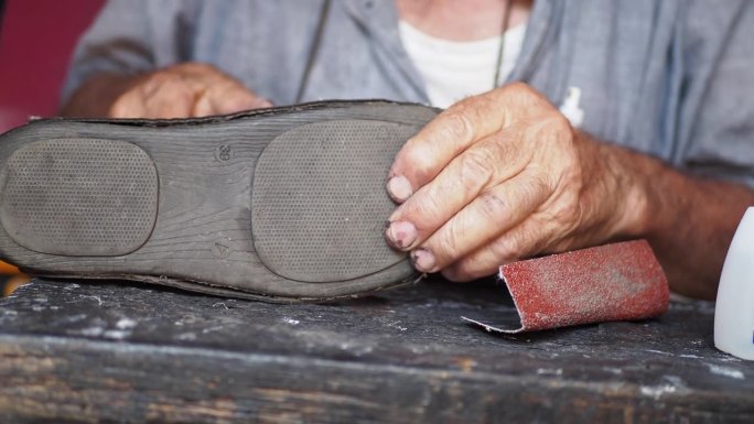 补鞋匠的手在补鞋，用针在缝