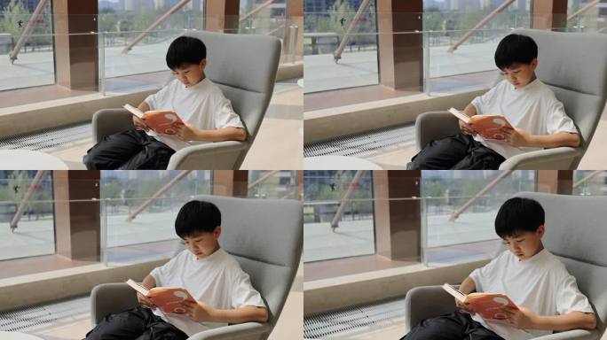 中国小男孩在图书馆大厅看书