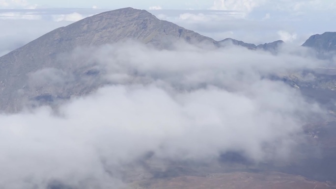 在夏威夷毛伊岛的哈雷阿卡拉山顶，厚厚的云层覆盖着火山口，这是电影般的特写镜头。30fps的4K HD