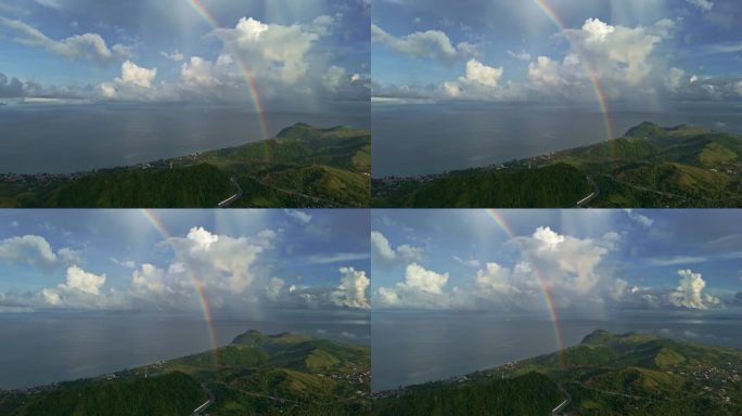 美丽的彩虹4k从右到左平移航拍在海洋和山脉的雨中的彩虹。
