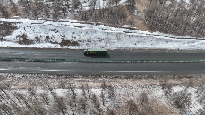 风雪天气道路上行驶的中国邮政物流汽车