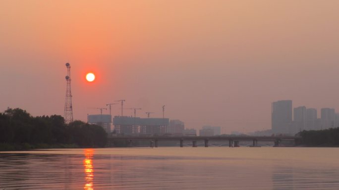 河边落日夕阳西下水天一色太阳照在水面上