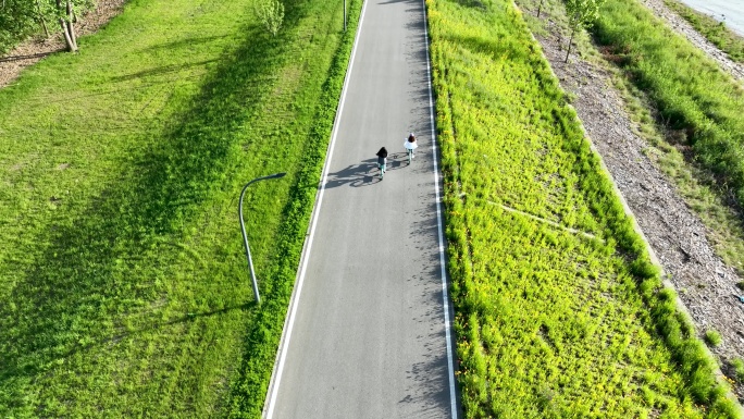 骑行爱好者在长江边环岛路上骑自行车运动