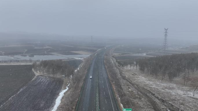 风雪中高速公路上行驶的汽车