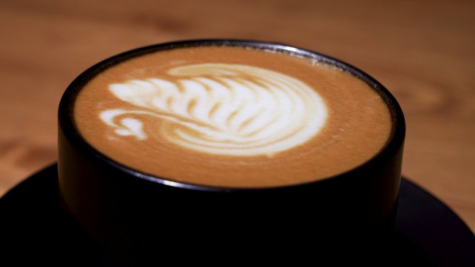 咖啡拉花艺术，天鹅图案拉花的香醇拿铁咖啡