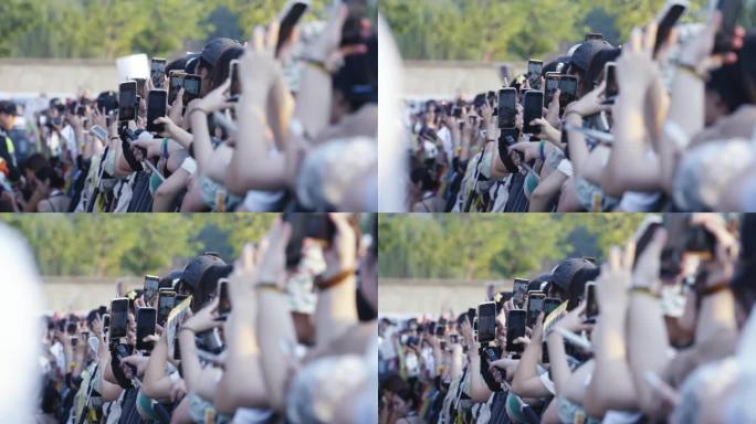 演唱会音乐节前排的歌迷观众拿着手机录视频