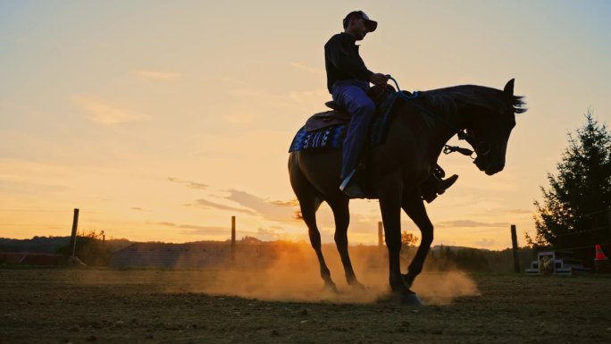 日落时分，橙色天空下训练时，牧场主骑着马在沙地牧场上旋转