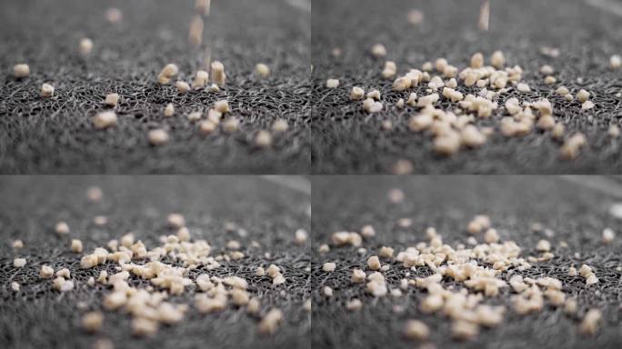 可生物降解的环保小猫玉米垃圾颗粒落在橡胶猫垫上的慢动作近距离旋转